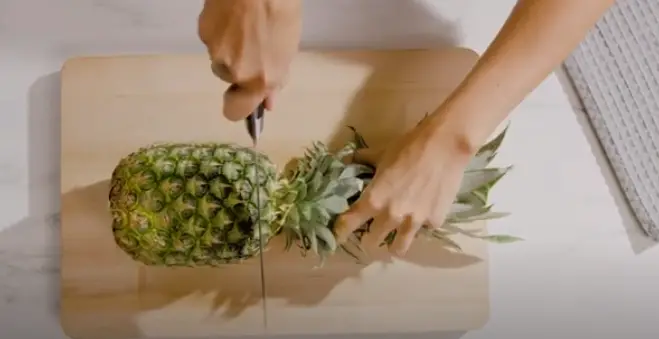 Slice off the top of the pineapple