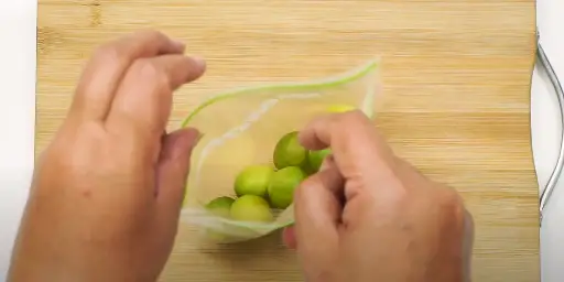 Take a sealed bag or a container and place the limes in it