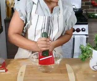 Begin slicing the cucumber Begin slicing the vegetable or fruit