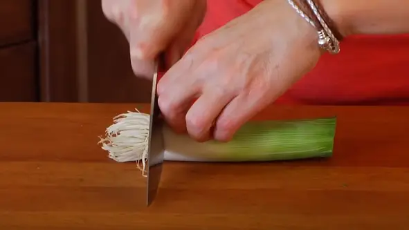 Cut the base of the leek Cut off the base of the leek