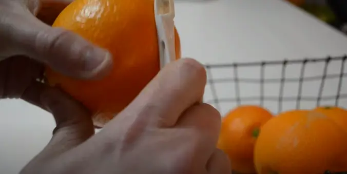 Use a sharp vegetable peeler to cut away the orange's skin carefully How To Peel An Orange With Peeler