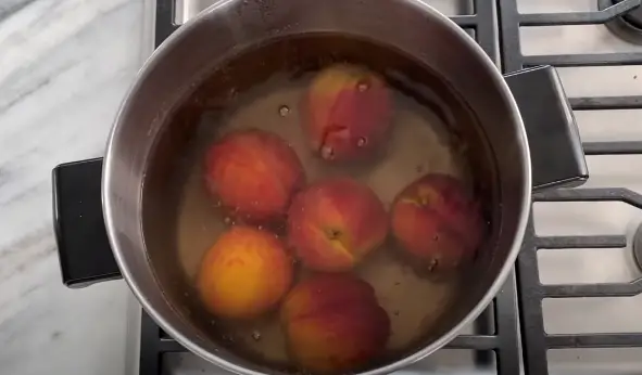 Once the water is boiling, place the peaches in the pot Once the water is boiling