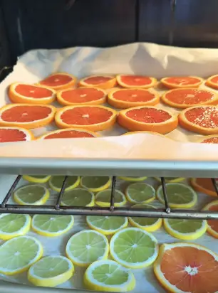 Place the baking sheet with the orange slices in the preheated oven Place the baking sheet with the orange