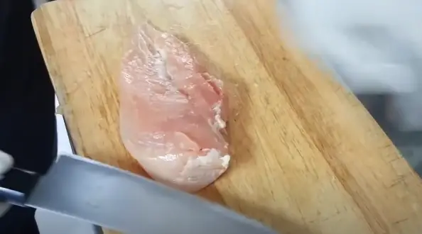 Place the chicken breast flat on a cutting board Place the chicken breast flat on a cutting board
