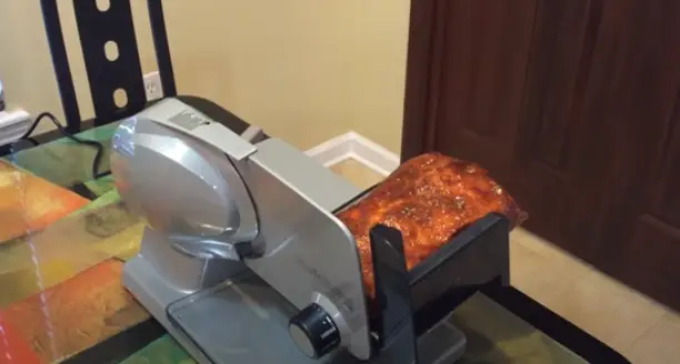 Place the partially frozen meat on the slicer