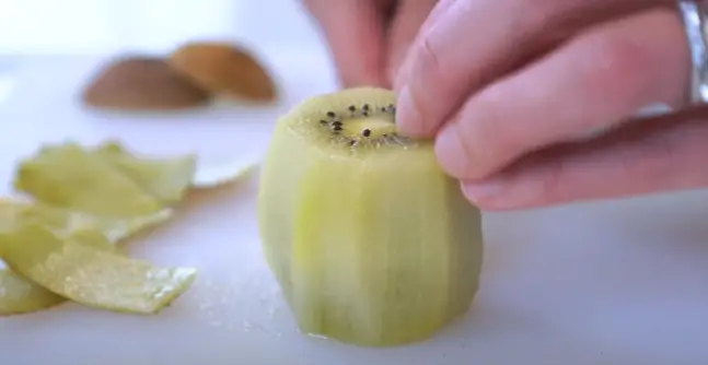 Rotate the fruit and repeat this around the entire kiwi until all of the skin is removed Rotate the fruit and repeat