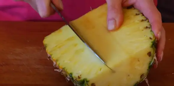 Slice each half of the pineapple