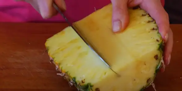Slice half of the pineapple Slice each half of the pineapple