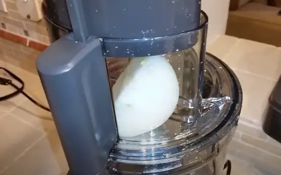 Use the food pusher to gently guide the onions down into the feed tube Use the food pusher