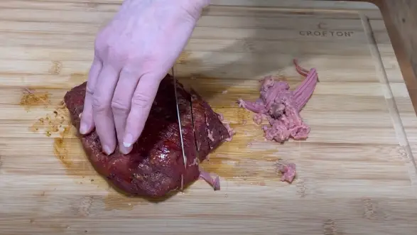Using a sharp knife, slice the brisket against the grain Using a sharp knife
