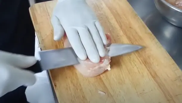 Using a sharp knife, carefully slice the chicken breast horizontally Using a sharp knife