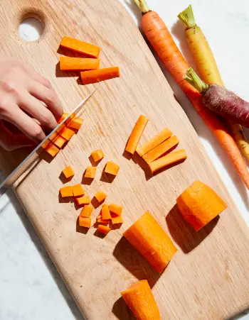 Dicing involves slicing the carrot into long lengths, then chopping these lengths into cubes. Diced