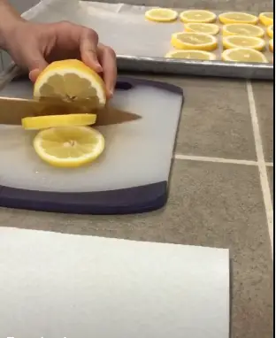 Slice the halved lemons into thin pieces. Remember to be careful and avoid cutting your finger Slice the halved lemons into thin pieces